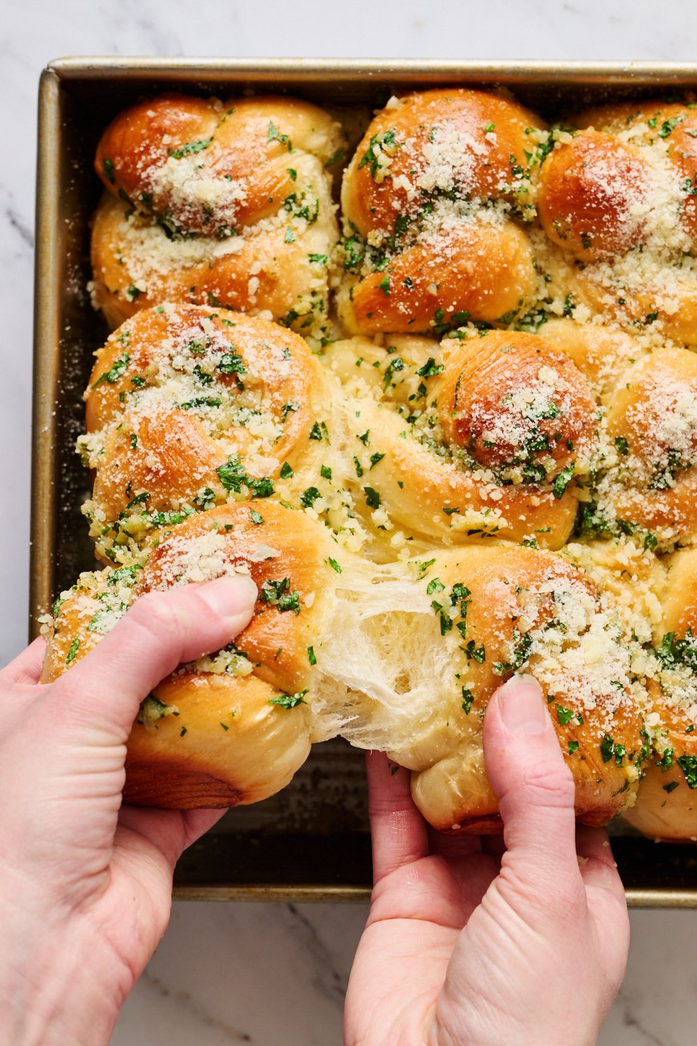 a soft garlic knot being pulled apart, showing how soft they are.