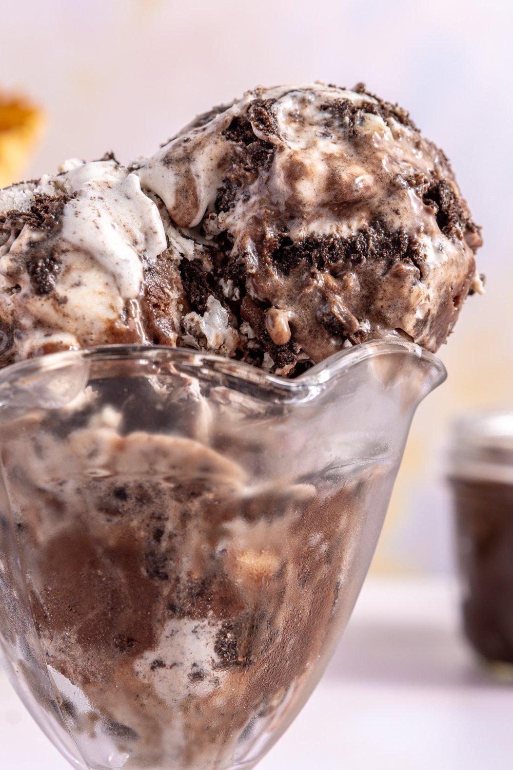 Scoops of cookies and cream ice cream in an old-fashioned glass sundae cup