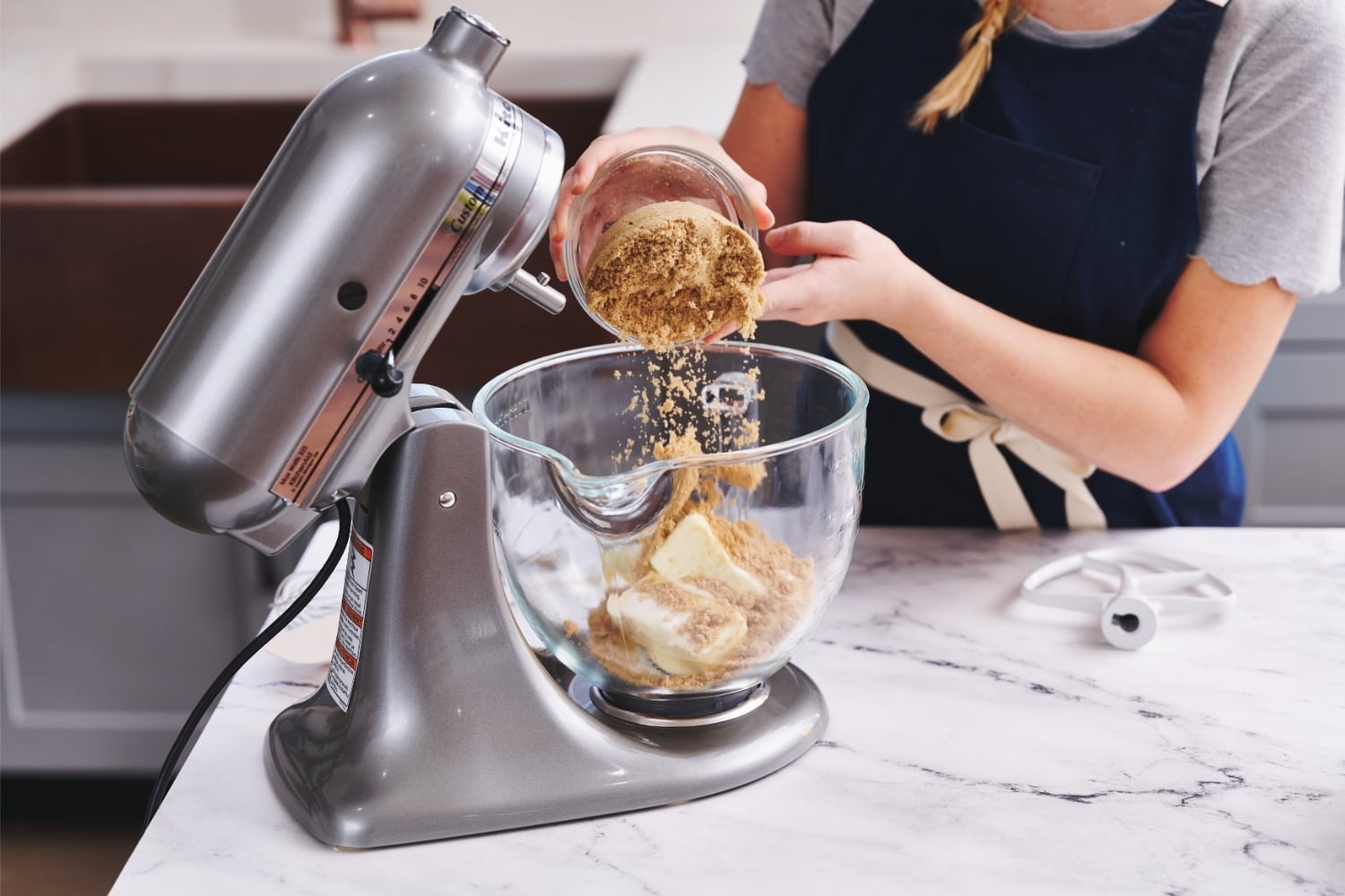 Tessa adding brown sugar to the mixing bowl
