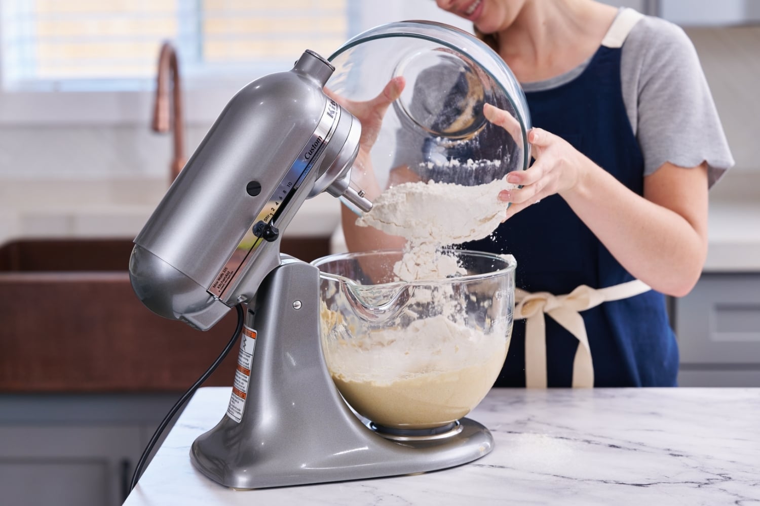 Tessa adding dry ingredient mixture into stand mixer bowl