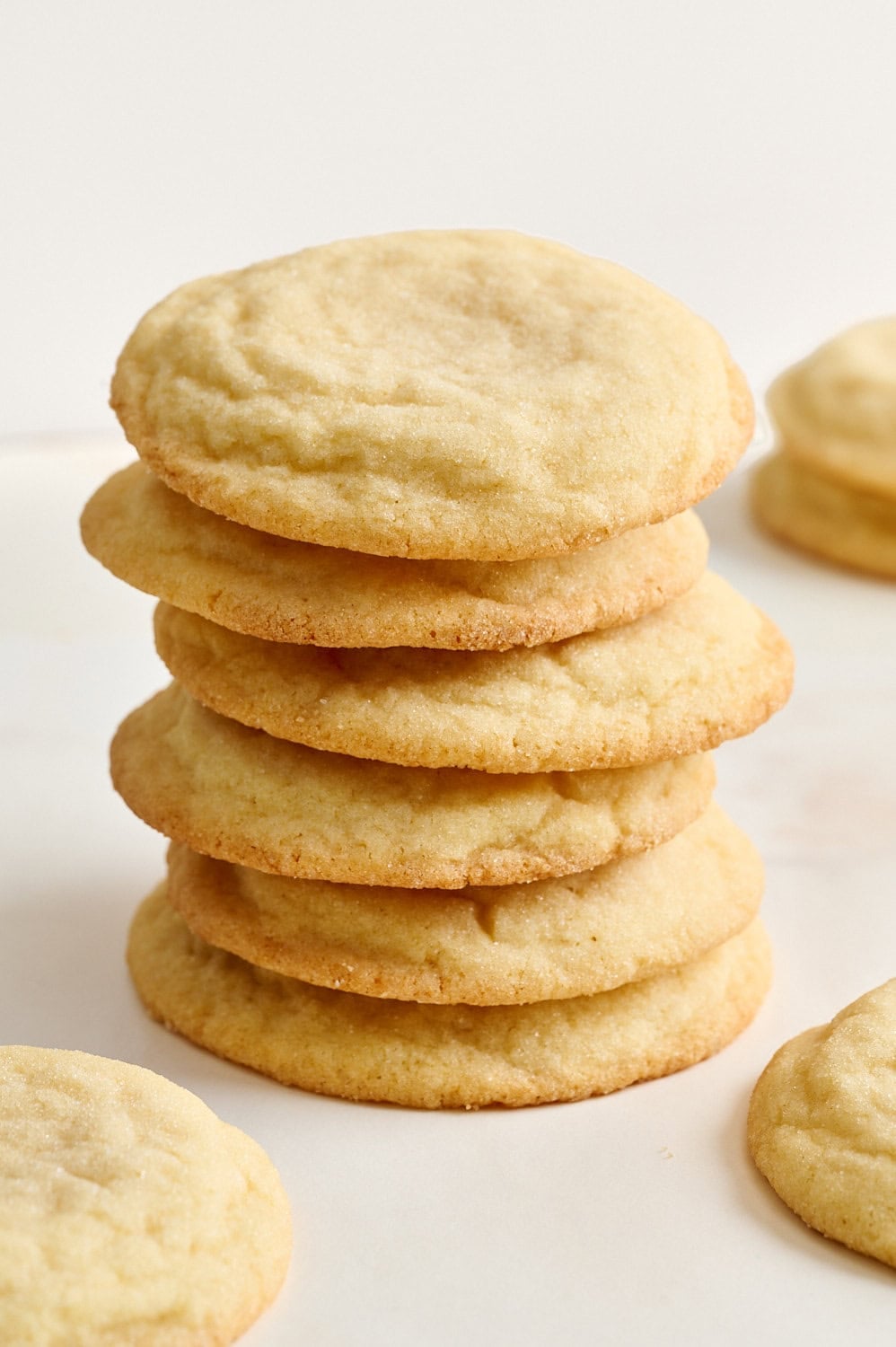 stack of thick, soft, and chewy sugar cookies on a neutral surface
