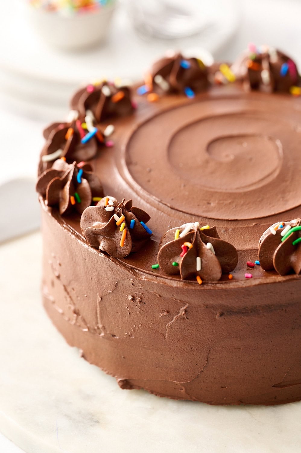 frosted chocolate cake on a marble cake plate