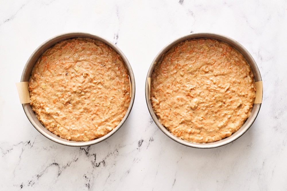 cake batter divided into two prepared cake pans