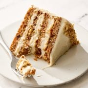 slice of brown butter carrot cake on a plate with a fork