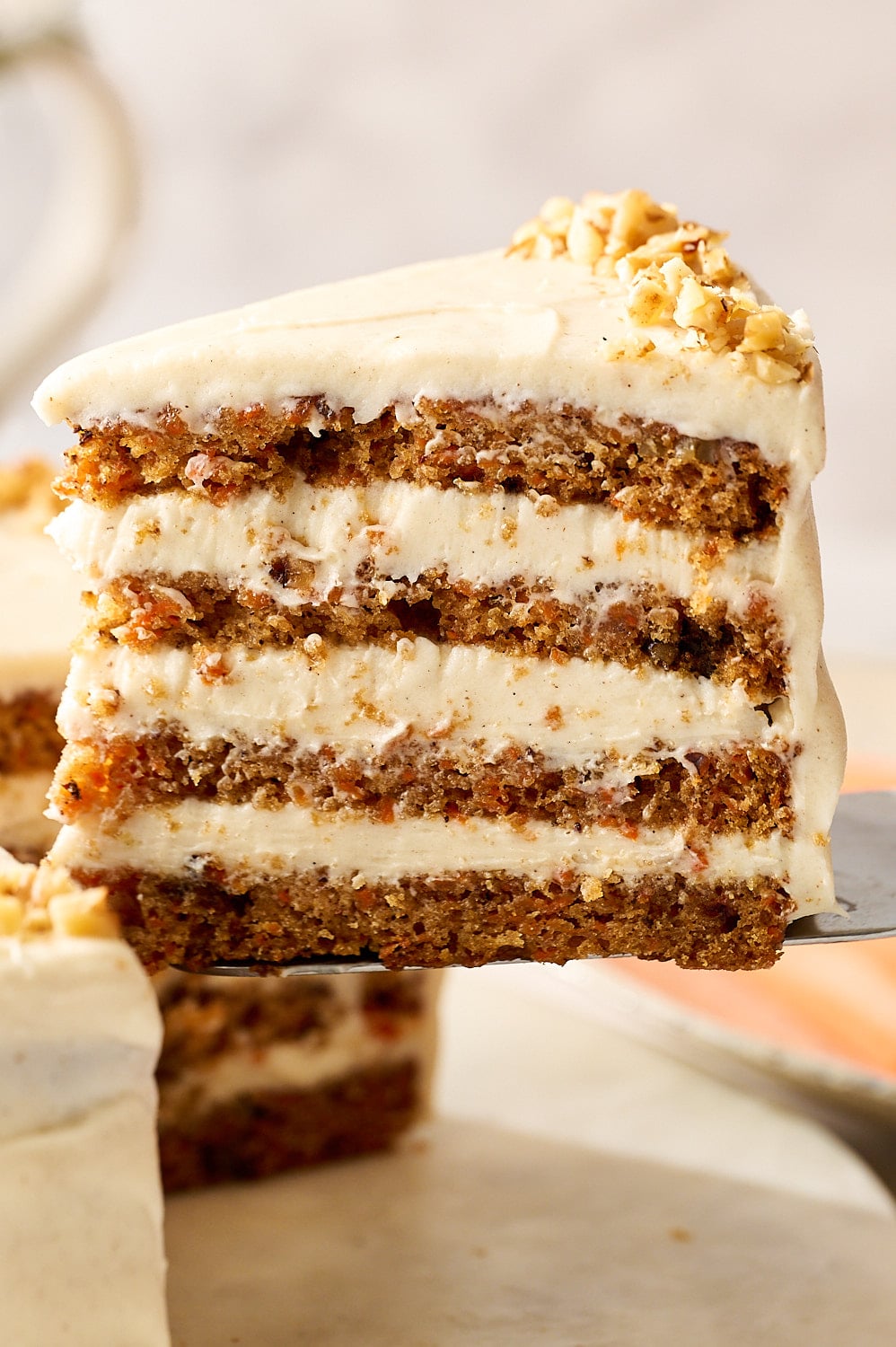 slice of carrot cake with four layers being pulled from cake