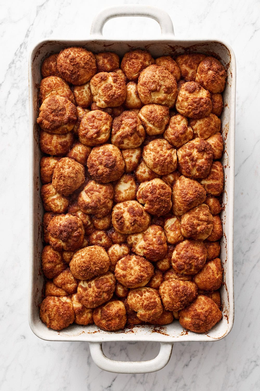 overhead view of cinnamon bun bites in pan, right after baking