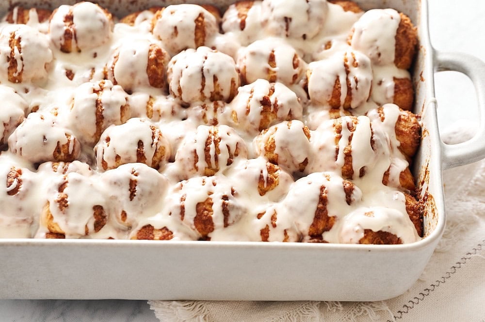 tray of iced cinnamon bun bites on a napkin on a marble counter