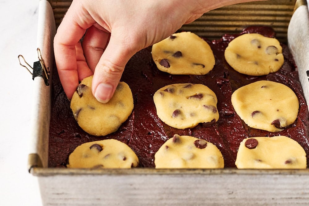 topping the brownie layer with nine disks of flattened cookie dough