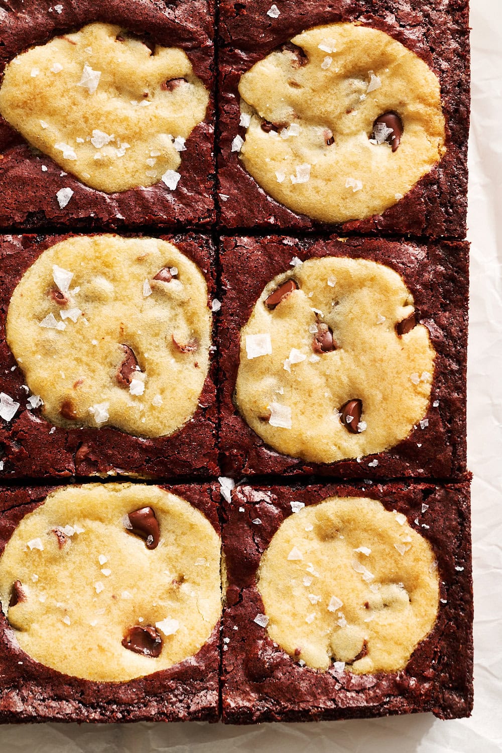 Overhead up close view of homemade brookies on parchment, sliced into 9 squares