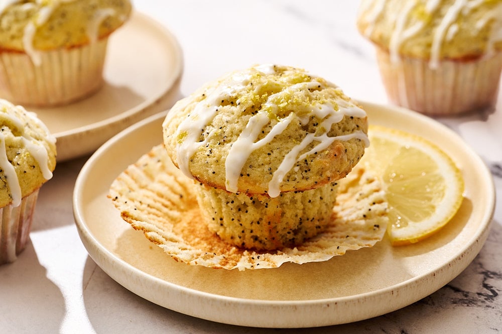 lemon poppyseed muffins on plates with lemon slices for garnish
