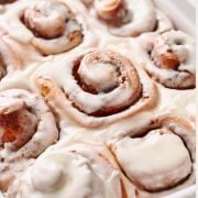 closeup of gooey cinnamon rolls topped with vanilla icing