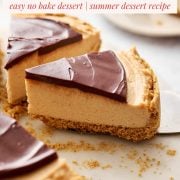 Close up of sliced peanut butter cheesecake with chocolate topping on a serving platter
