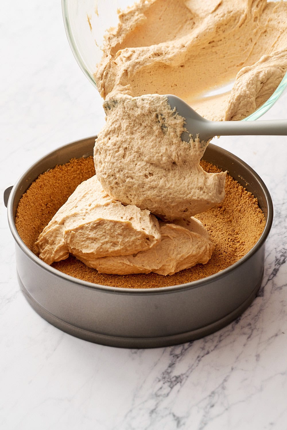 adding peanut butter filling to the graham cracker crust