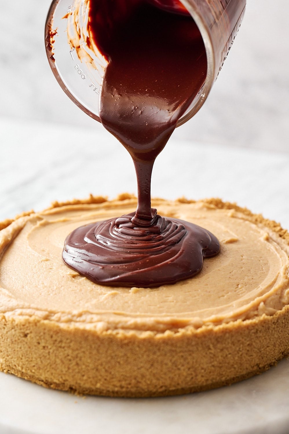 topping chilled cheesecake with ganache