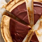 overhead view of cheesecake cut into slices with a cake server about to remove one