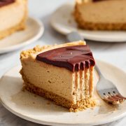 slice of no bake peanut butter cheesecake on a plate with a fork and a bite taken out