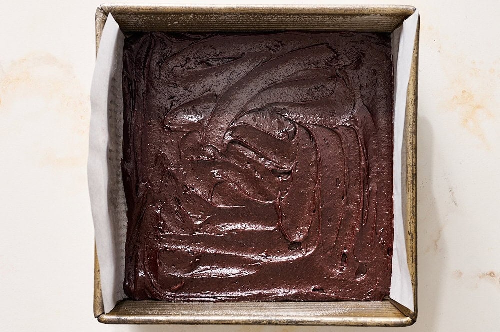 brownie batter in pan, ready to be topped with frozen biscoff sheet