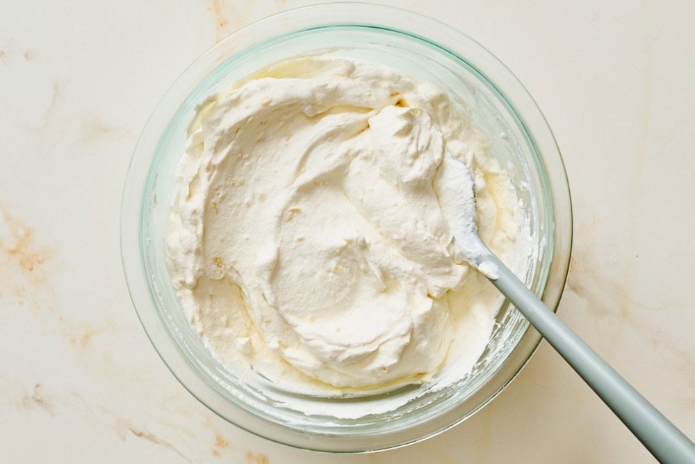 Light and fluffy mascarpone whipped cream filling in a mixing bowl
