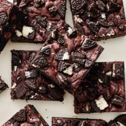 several Oreo brownies cut into perfect squares on a light marble surface