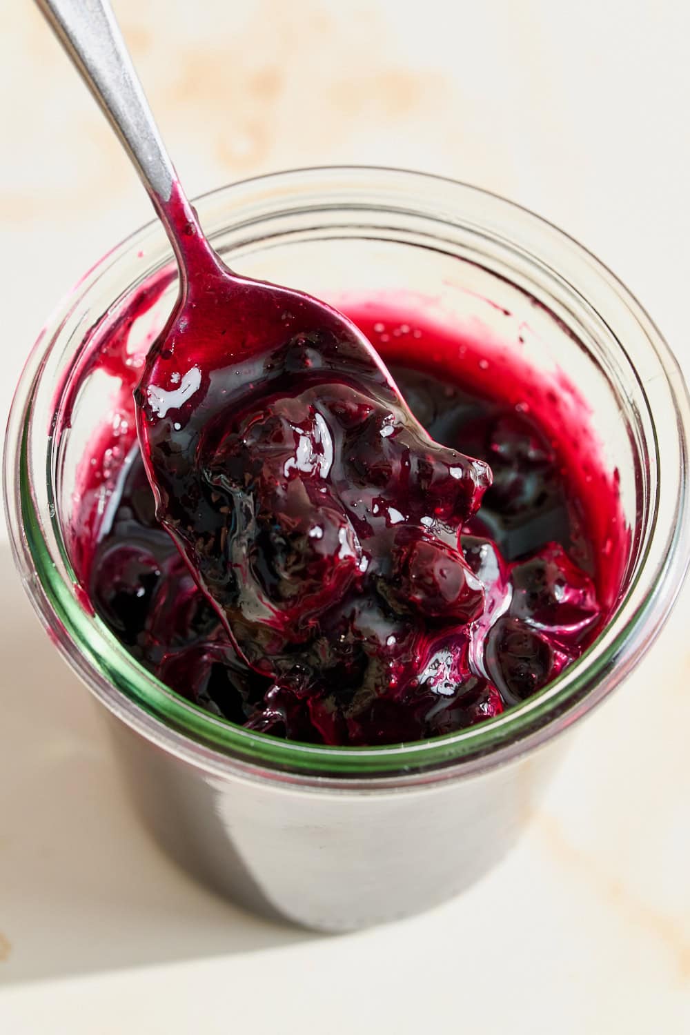 homemade blueberry sauce in a glass weck jar with a spoon