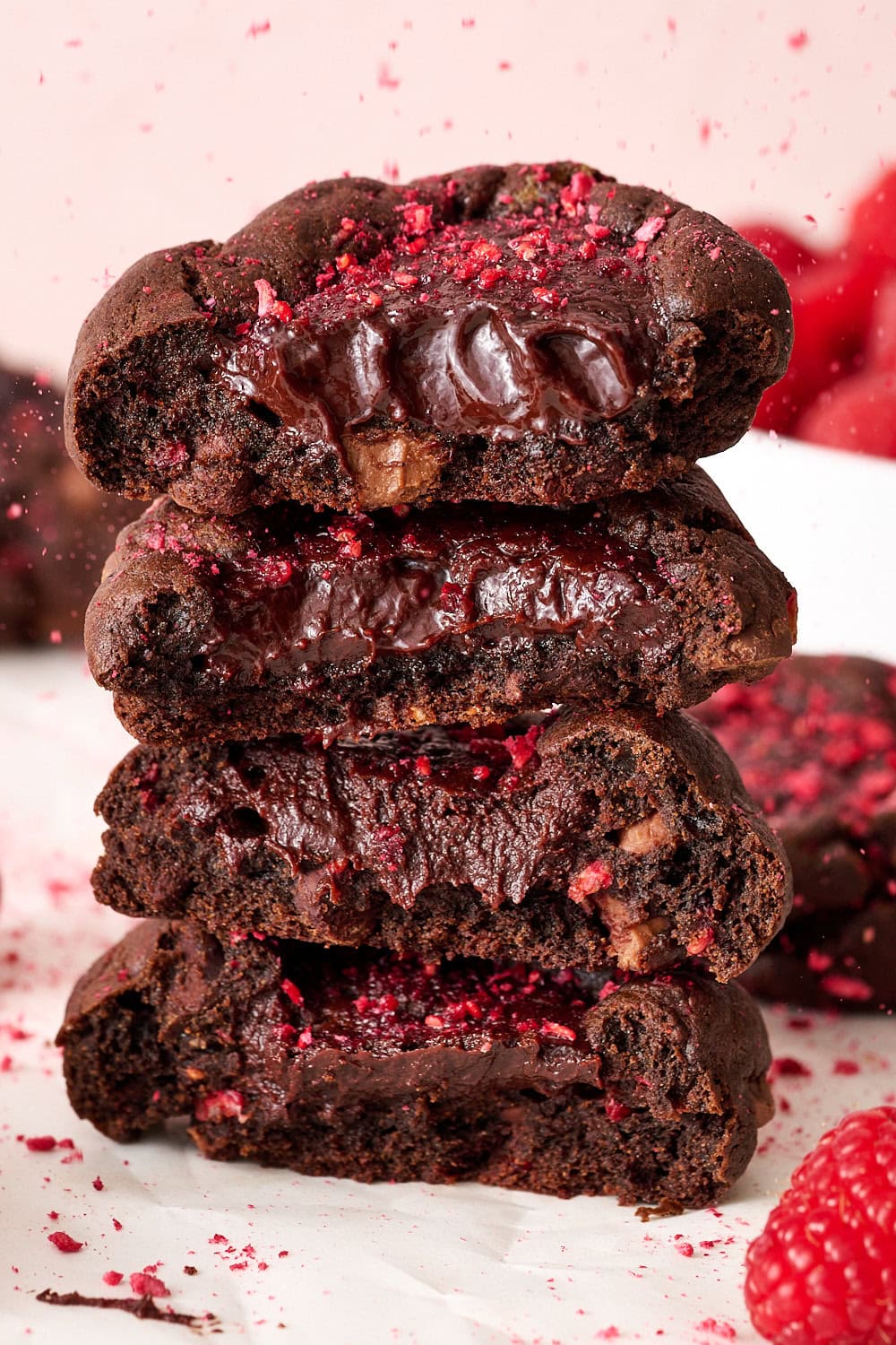 stack of chocolate raspberry truffle cookies all cut in half to reveal the fudgy centers
