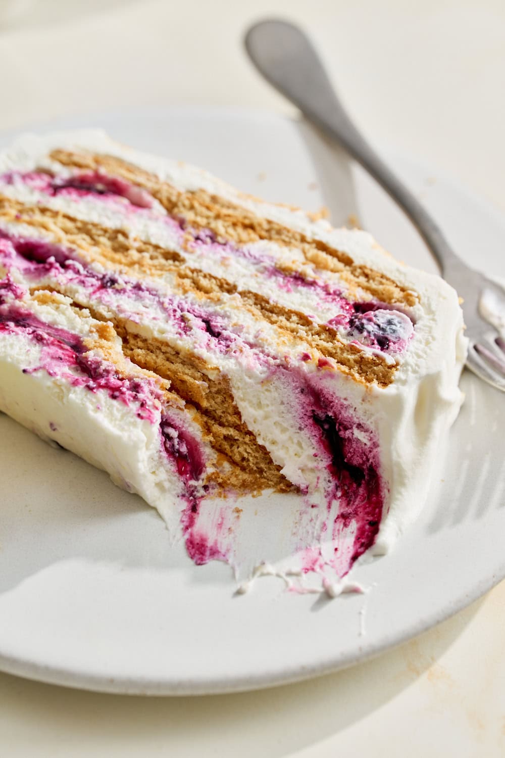 slice of blueberry lemon icebox cake on a plate with a forkful removed