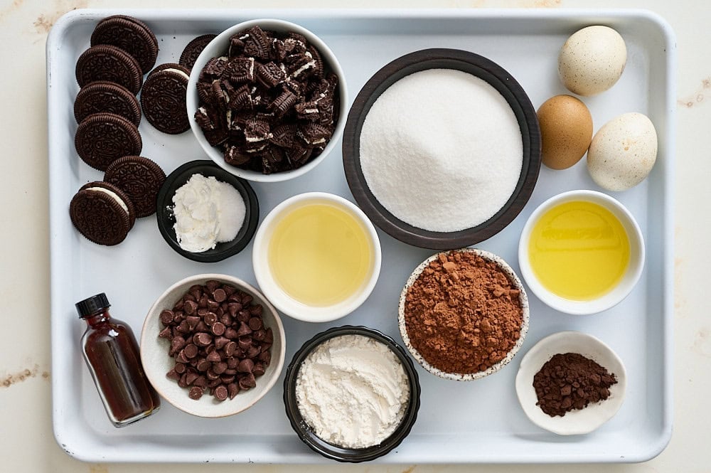 Oreo brownie ingredients measured and ready on a white rimmed baking tray