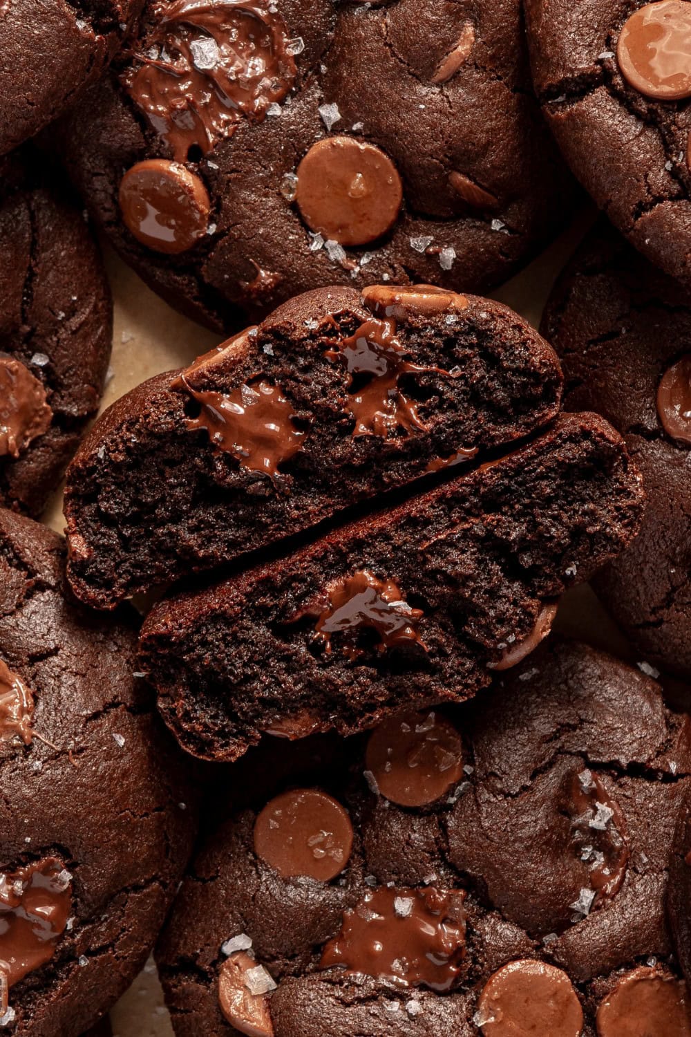 double chocolate chip cookies with one broken in half showing the melty, gooey chocolate chips inside