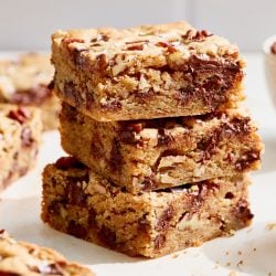 eye level view of a stack of three bourbon pecan chocolate chunk blondies
