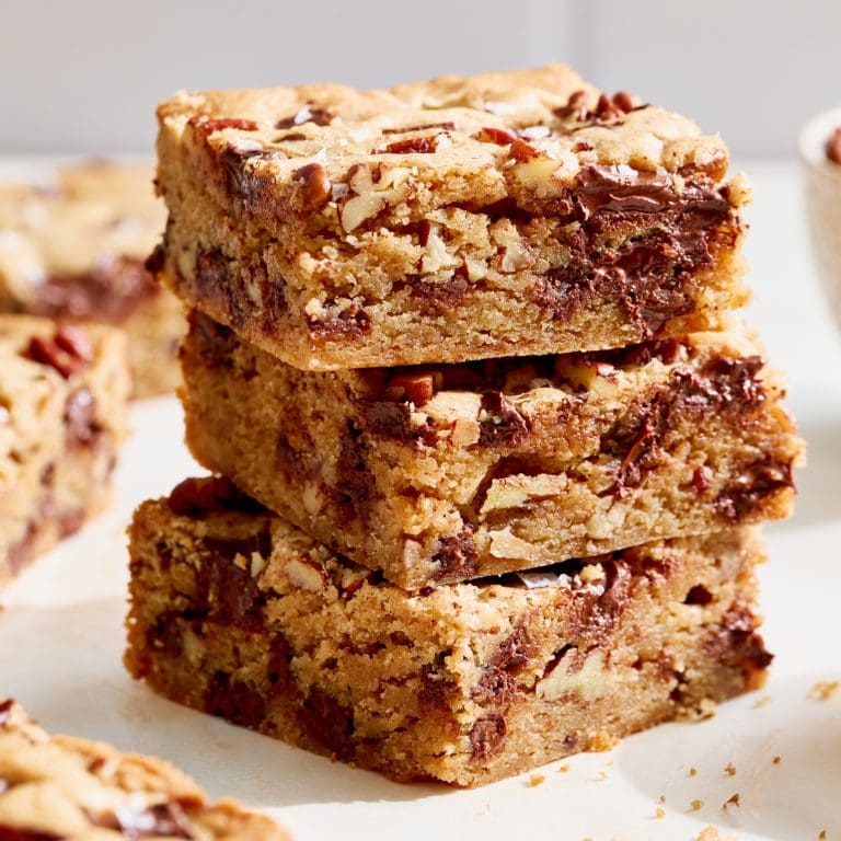 eye level view of a stack of three bourbon pecan chocolate chunk blondies