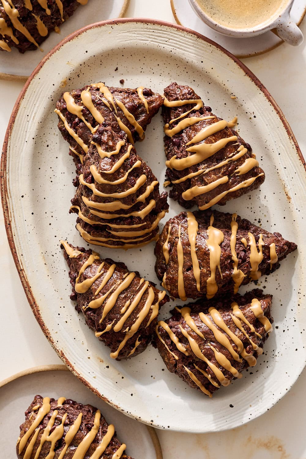 overhead view of a small platter of mocha scones with an espresso glaze and a cup of coffee