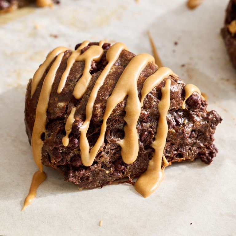 up close view of one mocha scone with espresso glaze on a parchment lined baking tray