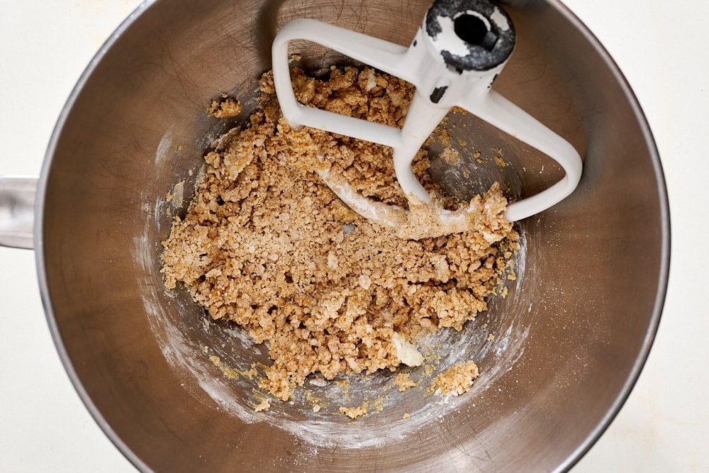 overhead view of mixing bowl containing crumbly peanut butter pumpkin mixture before it's done mixing