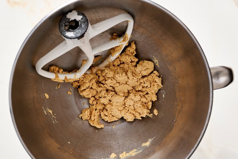 overhead view of mixing bowl containing less crumbly but still loose peanut butter pumpkin mixture