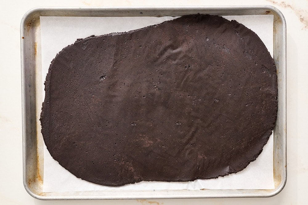 overhead view of black cocoa halloween cookie dough rolled into a rectangle