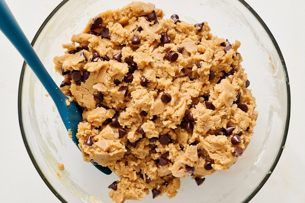 overhead view of final peanut butter toffee chocolate chip cookie dough in glass bowl