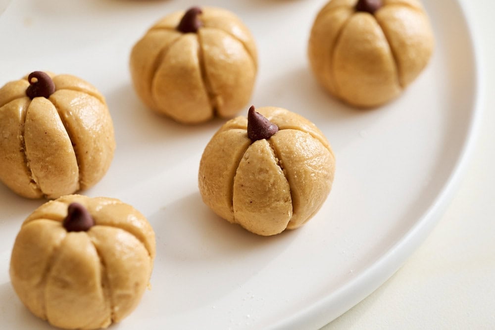 close up of several peanut butter pumpkins on a white plate