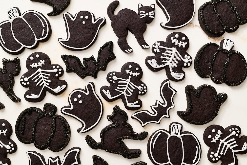 overhead view of many decorated black cocoa halloween cookies