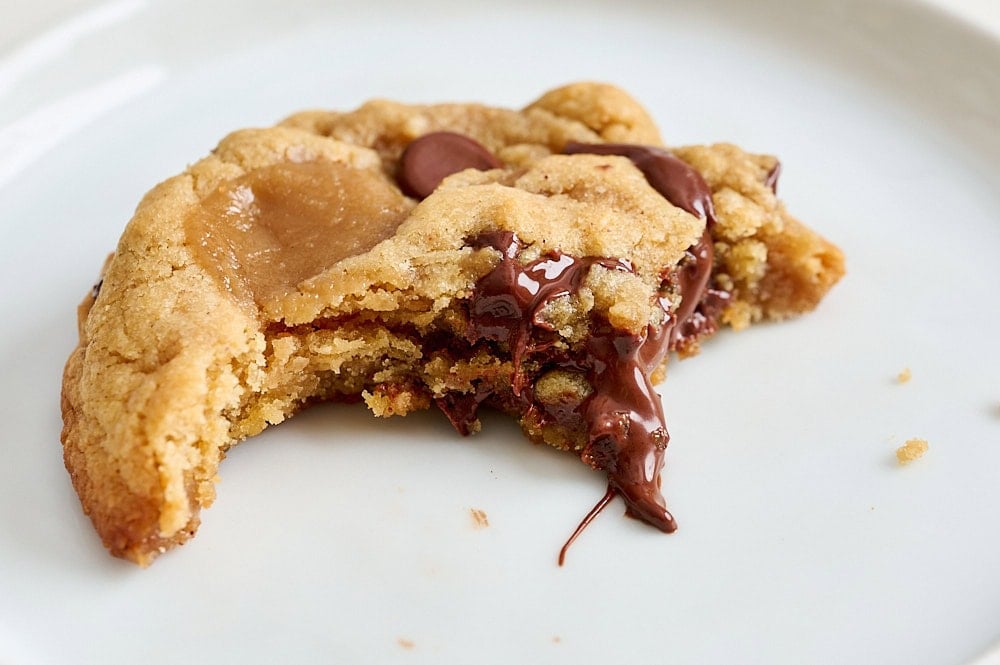 close up view of a half-eaten cookie to show chewy and chocolate gooey interior