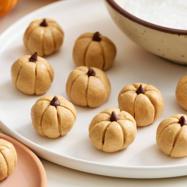 three quarter angle view of several peanut butter pumpkins on a white rimmed plate