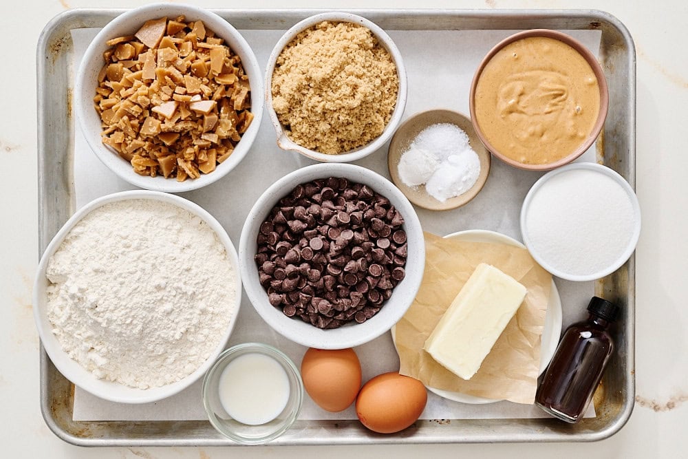 overhead view of all cookie ingredients portioned on a rimmed baking sheet