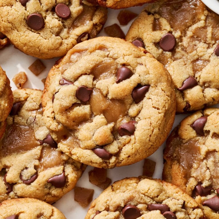 overhead view of many peanut butter toffee chocolate chip cookies spread out on a marble surface