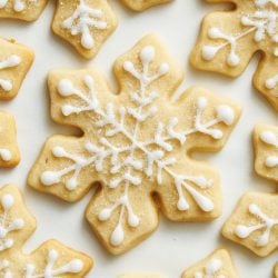 overhead view of decorated snowflake sugar cookies on a light colored surface